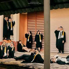 a group of people dressed in black and yellow sitting on the ground next to each other