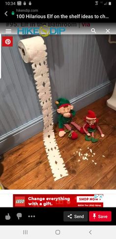 two stuffed animals sitting on the floor next to a roll of toilet paper that has been torn off