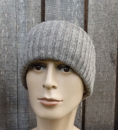 a mannequin head wearing a gray knitted hat