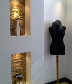 a mannequin is standing in front of a wall with two vases on it