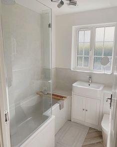 a bathroom with a sink, toilet and bathtub next to a window in it