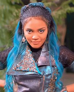 a barbie doll with blue hair wearing a black leather jacket and silver pants, holding her arms out