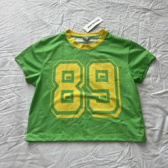 Urban Outfitters 89 Jersey Baby Tee Size Medium Condition: Nwt Color: Green / Yellow Details : - Open Jersey Knit - Comfy - Short Sleeve Top - Sports Jersey Reimagined In A Baby Tee Silhouette. - Cropped Above The Waist In A Relaxed Fit With A Crew Neckline. - Finished With A Varsity Graphic At The Front. Extra: - I Ship Between 1-2 Days Dr Wardrobe, Style Moodboard, Baby Yellow, Comfy Shorts, Urban Outfitters Tops, Baby Tee, Short Sleeve Top, Infant Tees, Green Yellow