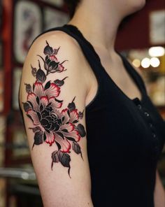 a woman with a black and red flower tattoo on her arm