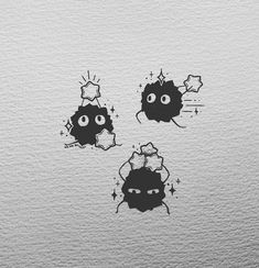 three black and white stickers on the side of a wall with two eyes looking at each other