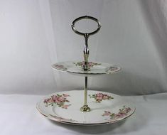 two tiered serving trays with roses on them, one holding a ring handle