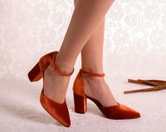 Walk into your special day with elegance and style in these burnt orange wedding shoes. Handmade with care, these stunning Orange Heels feature a chic ankle strap design and luxurious Burnt Orange Velvet material. Elevate your bridal look with the timeless beauty of "CASSIE", the perfect choice for a bride who wants to stand out on her wedding day.  *   HEEL HEIGHT: 6cm/2.36inch & 8cm/3.15inch/photo *   Fit : Normal *   Exterior: Velvet *   Interior: Genuine Leather  *   Handmade in Greece *   M Rust Velvet Shoes, Orange Velvet Wedding Shoes, Orange Wedding Heels, Orange Closed Toe Formal Heels, Orange Velvet Shoes, Orange Wedding Shoes, Orange Heels With 4-inch Round Toe, Orange High Heels, Burnt Orange Velvet