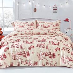 a red and white comforter set with christmas trees on the bed in front of a window