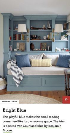 a room with blue bookshelves and pillows on the couch in front of it