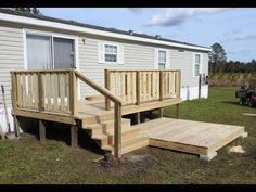 a wooden deck with steps leading up to a mobile home