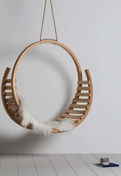 a wooden hanging chair with white feathers on it