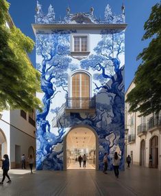 people are walking in front of a building with blue and white designs on the side