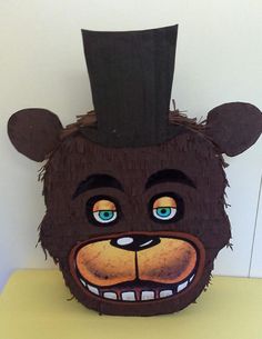 a brown bear with a top hat on it's head sitting on a table