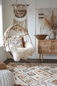 a hammock hanging from the ceiling in a room with pillows and rugs