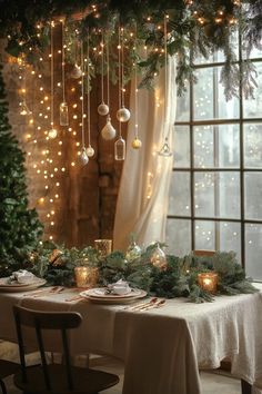 a dining room table set for christmas dinner with candles and ornaments hanging from the ceiling