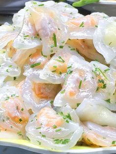 a plate filled with shrimp and dumplings covered in plastic wrap