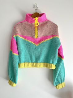 a colorful sweater hanging on a white wall