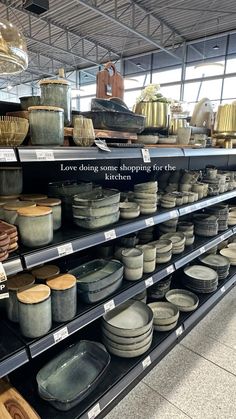 there are many bowls and plates on the shelves in this store that is full of them