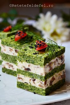 two pieces of green cake on a plate with flowers in the backgroung