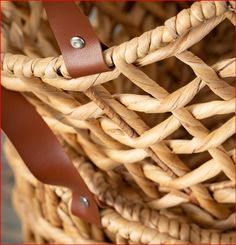 a close up of a basket with leather handles