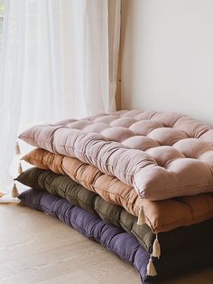 a stack of pillows sitting in front of a window