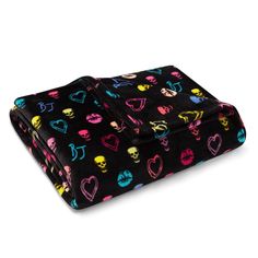 a black blanket with colorful skulls and hearts all over it, on a white background