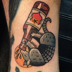 a tattoo on the arm of a man with an image of a bird and a bottle