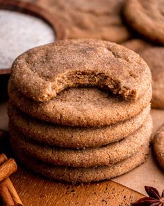 a stack of cookies sitting on top of a wooden table next to anisette