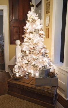 a white christmas tree with lights and presents