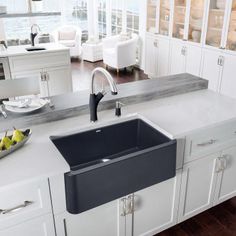 a kitchen sink sitting on top of a counter next to a bowl of lemons