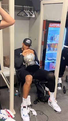 a man sitting in a chair holding a soccer ball