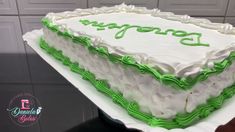 a large white cake with green frosting on top