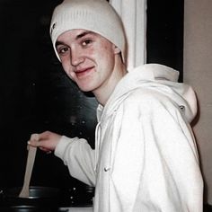 a man wearing a white hat and holding a wooden spoon