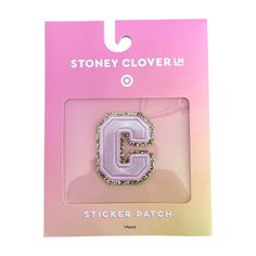 a pink and white sticker with the letter c in it's center on a card