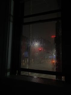 a window with rain drops on it at night