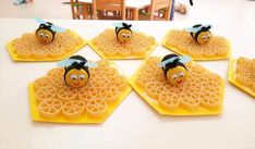 six waffles with faces on them sitting on a table in the shape of bees