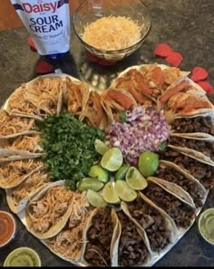 a large platter filled with lots of food on top of a table next to condiments