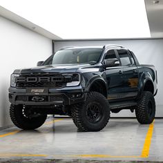 a large black truck parked in a garage