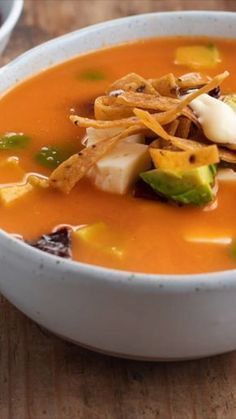 a white bowl filled with soup on top of a wooden table