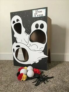 a cardboard box with fake ghost legs and decorations on the floor in front of it