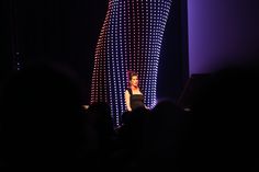 a woman standing on top of a stage in front of a crowd