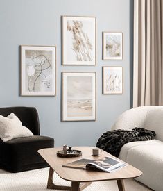 a living room filled with white furniture and pictures on the wall above it's coffee table