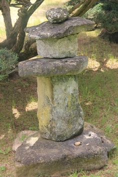 some rocks stacked on top of each other in the grass