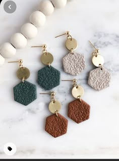 six different color hexagon earrings on a marble surface