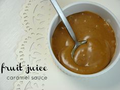 a bowl filled with peanut sauce on top of a white doily next to a spoon