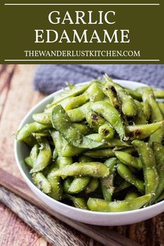 garlic edamame in a white bowl on top of a wooden table with text overlay