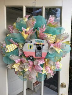 a wreath that is on the front door with a camera attached to it's side