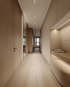 an empty room with wooden floors and white walls, is lit by recessed lighting