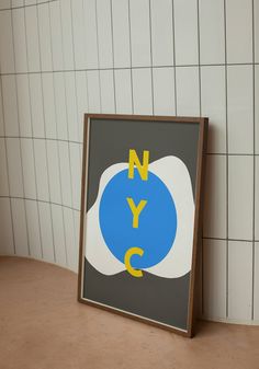 a blue and yellow sign sitting on top of a table next to a white tiled wall