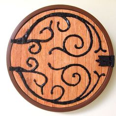 a wooden clock with black iron work on it